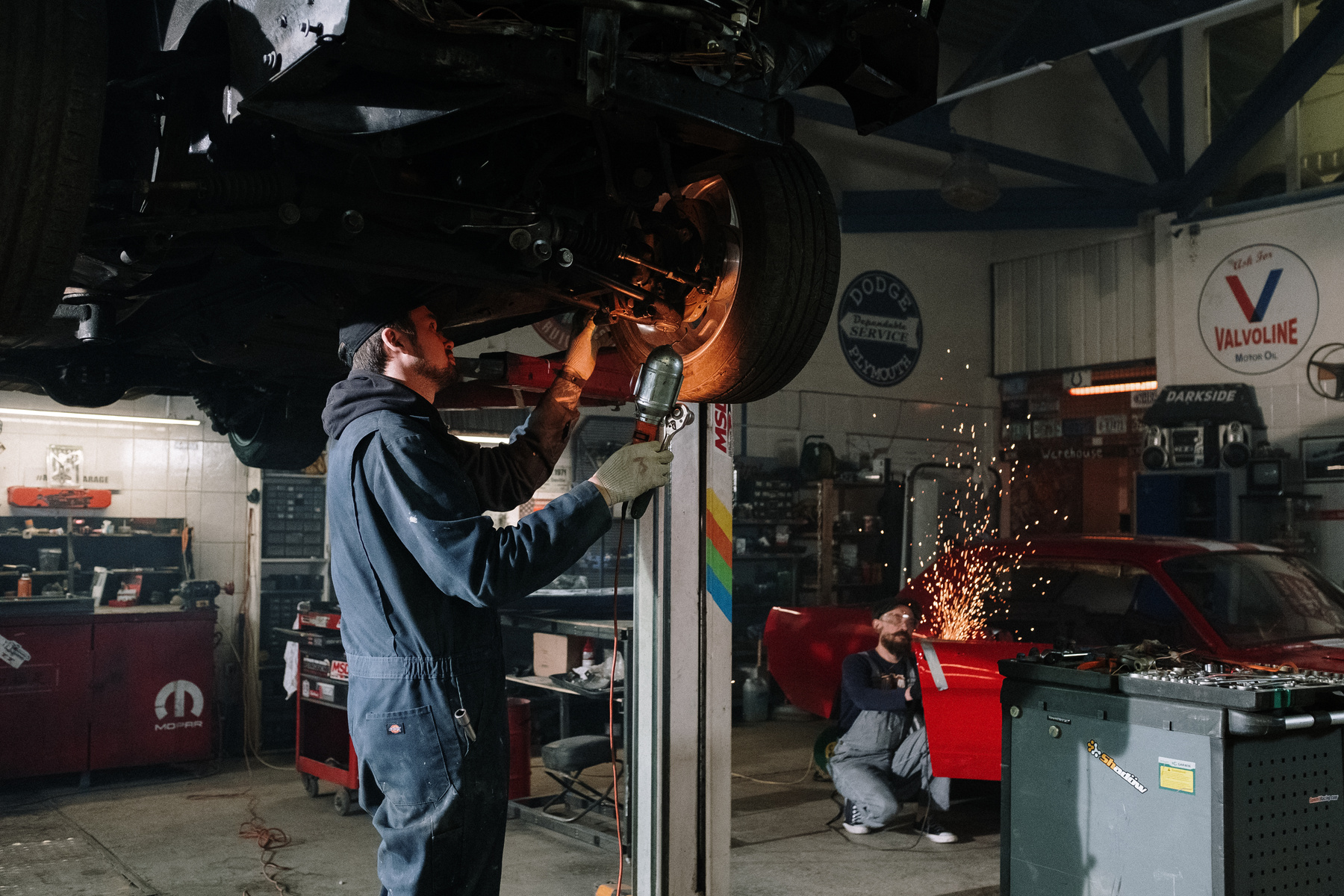 Man in Blue Denim Jacket Holding Brown Metal Pipe